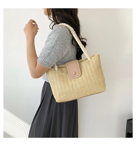 Détail du sac cabas en paille avec rabat en cuir contrasté et poignée en corde