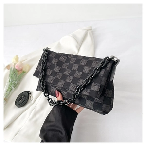 Detail of checkered crossbody bag with black chain strap and pleated texture finish
