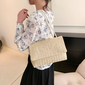 Minimalistische beige gewebte Umhängetasche mit weißem Seilriemen getragen von einem Model
