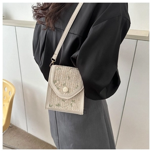 Detail of hand-woven crossbody bag with floral embroidery and thin shoulder strap