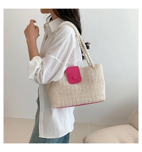 Détail du sac en paille avec rabat en cuir rose vif et bandoulières en corde épaisse