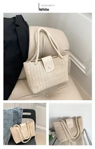 Gros plan détaillé du sac cabas en paille tissée avec rabat en cuir et anses en corde