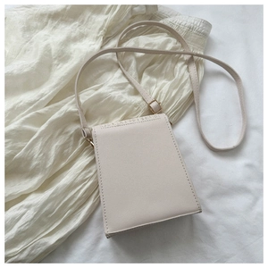 Detail shot of laser-cut openwork pattern on cream minimalist straw-textured square bag