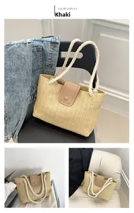 Détail du sac cabas en paille kaki avec anses en corde de coton blanc et fermoir en cuir