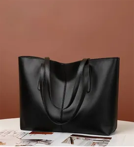 Minimalist black matte faux leather tote bag showing large capacity and vertical seam detail