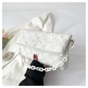 Detail of white checkered fabric and acrylic chain on stylish women crossbody bag