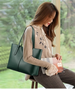 Deep green large tote bag with lychee texture held by a model in a lifestyle setting