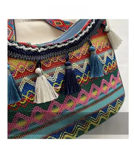 Detailed macro view of ethnic woven shoulder bag with colorful geometric patterns and tassels