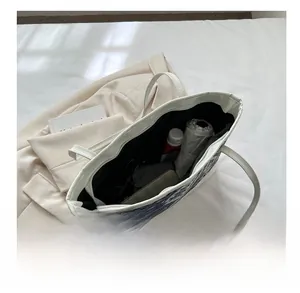 Grand sac fourre-tout montrant sa capacité pour parapluie, portefeuille et maquillage
