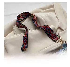 Detailed close-up of ethnic style embroidered shoulder strap with golden metal hook