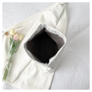 Detailed interior of a silver textured crossbody bag with chain and spacious dark lining