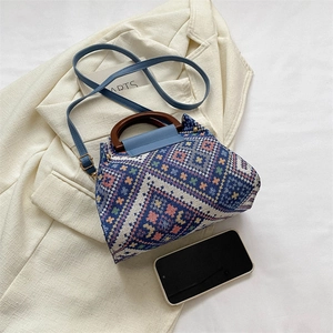 Detailansicht der geometrischen Web-Tasche mit runden Holzgriffen und blauem Lederriemen