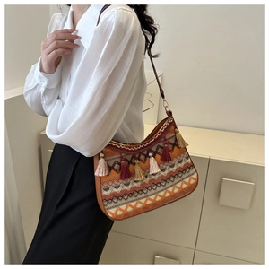 Detail of bohemian ethnic shoulder bag with vibrant geometric embroidery and fringe tassels