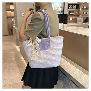 Detail of lavender woven tote bag featuring a cotton rope handle and white lace bow detail