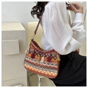 Detailed close-up of Bohemian bag with ethnic embroidery and colorful tassel charms