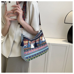 Detail of bohemian shoulder bag with colorful fringe tassels and geometric woven patterns