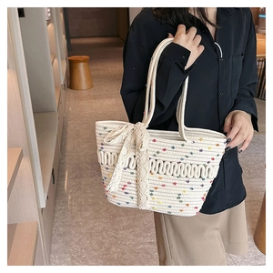 Close-up of handmade woven tote bag with colorful specks and delicate lace bow detail