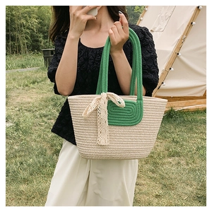 Detailed weave of beige tote bag with green accents and elegant lace bow decoration