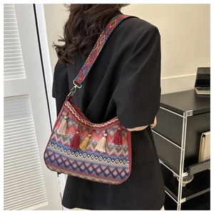 Close-up of bohemian woven shoulder bag with colorful tassels and geometric patterns