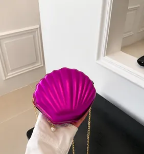 Close-up of rose purple metallic shell bag with golden chain and pearl charms