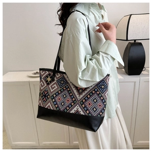 Detail of high-capacity tote bag with colorful geometric patterns and black leather base