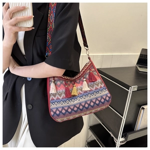 Detail of bohemian shoulder bag with ethnic geometric patterns and colorful fringe tassels
