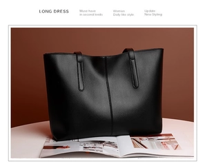 Detail of a large black leather tote bag featuring vertical stitching and dual shoulder straps