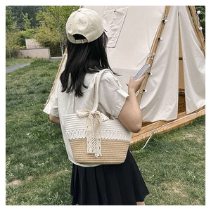 Detail of handwoven tote bag with lace bow and bicolor design in a camping setting
