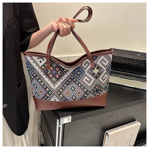 Close-up of retro woven tote bag with geometric patterns and brown leather straps