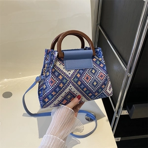 Detail of colorful woven ethnic fabric bucket bag with round dark wooden handle