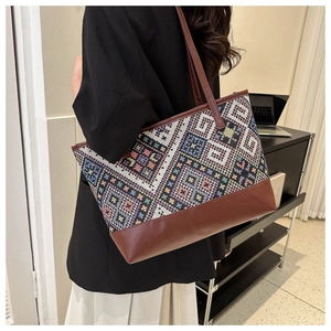 Detail of geometric pattern tote bag showing high-quality woven fabric and brown faux leather