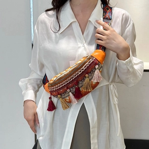 Ethno-Boho-Gürteltasche mit bunten Fransen und geometrischem Gurt auf weißem Hemd