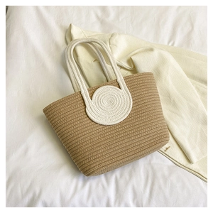 Detailed view of woven tote bag texture with decorative white spiral patterns on a strap