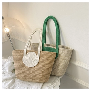 Detail of woven straw tote bags with colorful handles and round decorative accents