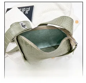 Detail view of crocodile pattern bag interior with silver zipper and luxury texture