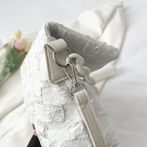 White quilted crossbody bag with chunky chain strap and textured grid pattern