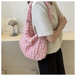 Detail view of the pink popcorn textured fabric on a trendy soft cloud shoulder bag