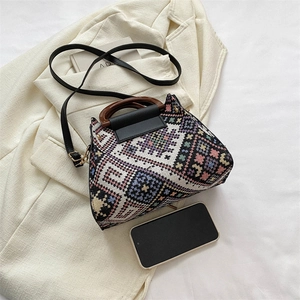 Detail der gewebten Beuteltasche mit Holzgriff und Handy zum Größenvergleich