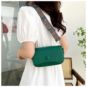 Detail of forest green leather crossbody bag with colorful ethnic style wide strap