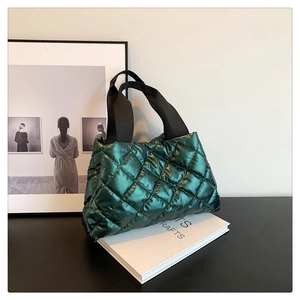 Détail du sac à main matelassé vert métallique avec surpiqûres losanges et sangle
