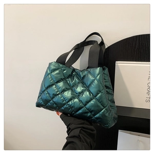 Détail du sac cabas matelassé vert foncé brillant avec motif à losanges et anses noires