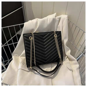 Detail showing black V-quilted faux leather bag with elegant gold metal chain straps