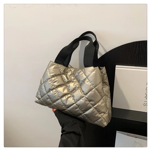 Détail du sac cabas matelassé doré champagne avec de larges anses noires en tissu