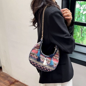 Detailed close-up of bohemian crescent bag featuring colorful woven textures and fringe