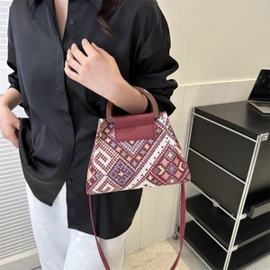 Detailansicht der gewebten Ethno-Beuteltasche mit Holzgriff und Lederklappe im Retro-Stil