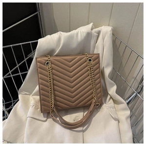 Detailed V-shaped quilting and gold chain strap on a brown leather commuter bag