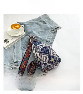 Detail view of ethnic knit chest bag with blue geometric pattern on denim jacket