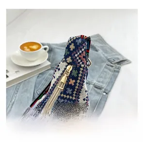 Gros plan d'une fermeture éclair dorée sur un sac à bandoulière tissé de style ethnique