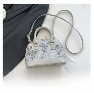 Mini shell bag size comparison with smartphone showing the compact interior storage