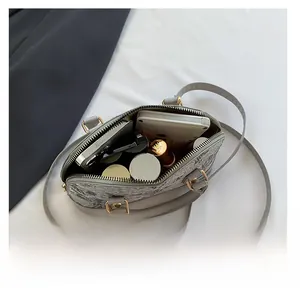 Top view of the grey shell bag interior showing storage for cosmetics and electronics